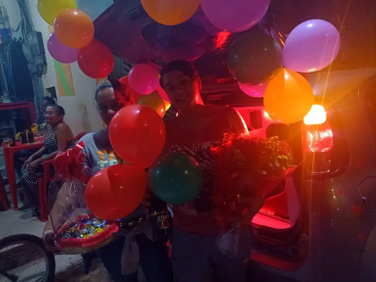 Close dos balões coloridos iluminados pela luz vermelha do carro