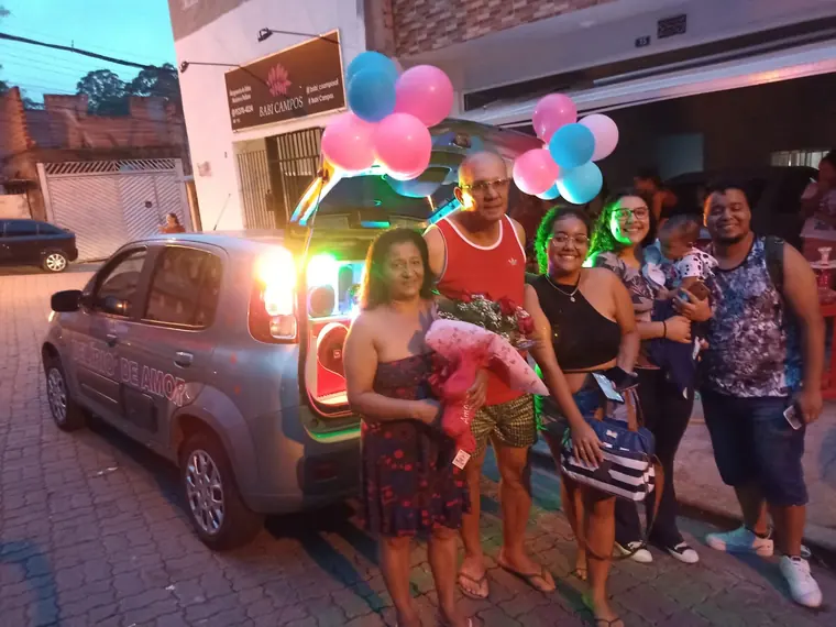 Família reunida ao lado do carro de som decorado com balões