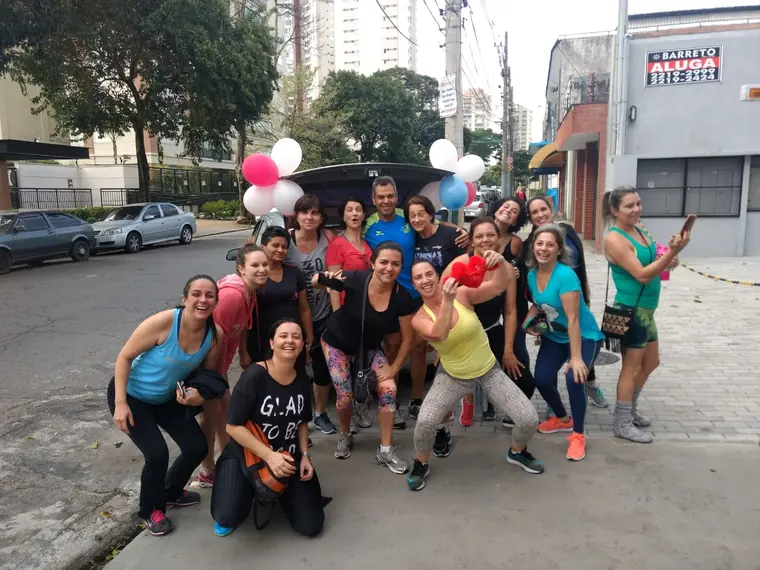 Grupo grande de pessoas posando com o carro de som ao fundo