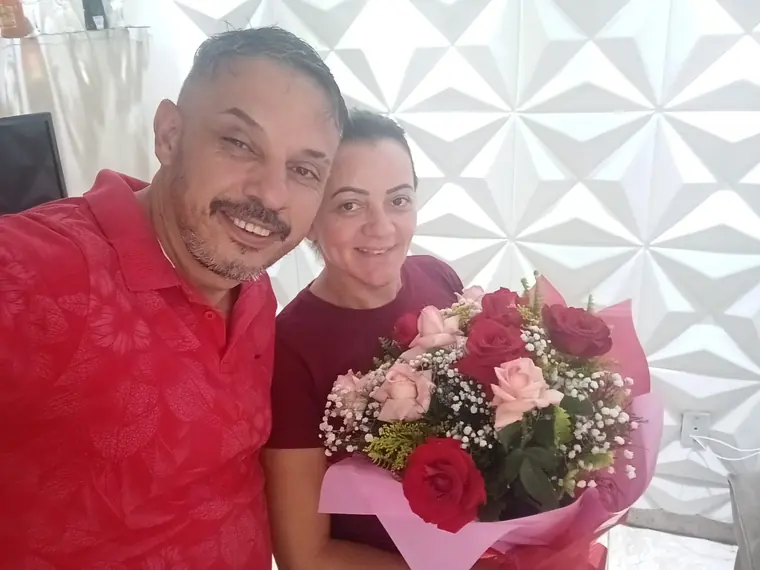 Casal segurando o buquê de rosas entregue na homenagem